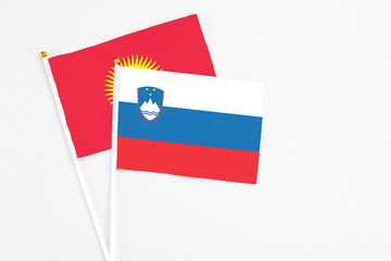 Slovenia and Kyrgyzstan stick flags on white background. High quality fabric, miniature national flag. Peaceful global concept.White floor for copy space.