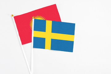 Sweden and Kyrgyzstan stick flags on white background. High quality fabric, miniature national flag. Peaceful global concept.White floor for copy space.