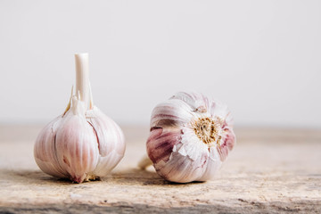 Garlic lie in a row on a rustic wooden background. Copy, empty space for text
