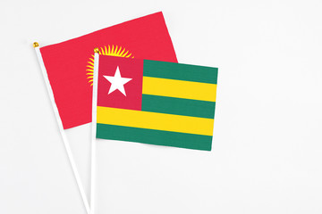 Togo and Kyrgyzstan stick flags on white background. High quality fabric, miniature national flag. Peaceful global concept.White floor for copy space.