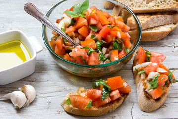 Ingredients to make bruschetta, typical Italian appetizer with tomato, basil and toast