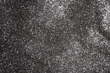 dark background in the form of a scattering of black and silver sequins