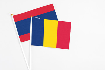 Fototapeta premium Chad and Laos stick flags on white background. High quality fabric, miniature national flag. Peaceful global concept.White floor for copy space.