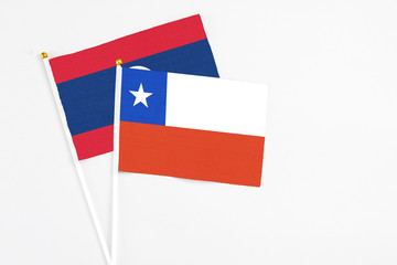 Chile and Laos stick flags on white background. High quality fabric, miniature national flag. Peaceful global concept.White floor for copy space.