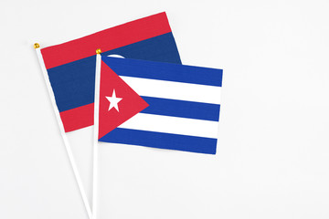 Cuba and Laos stick flags on white background. High quality fabric, miniature national flag. Peaceful global concept.White floor for copy space.
