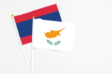 Cyprus and Laos stick flags on white background. High quality fabric, miniature national flag. Peaceful global concept.White floor for copy space.