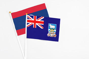 Falkland Islands and Laos stick flags on white background. High quality fabric, miniature national flag. Peaceful global concept.White floor for copy space.