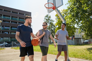 sport, leisure games and male friendship concept - group of men or friends going to play basketball outdoors - Powered by Adobe