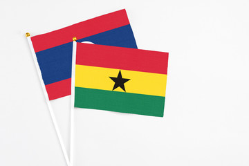 Ghana and Laos stick flags on white background. High quality fabric, miniature national flag. Peaceful global concept.White floor for copy space.