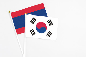 South Korea and Laos stick flags on white background. High quality fabric, miniature national flag. Peaceful global concept.White floor for copy space.