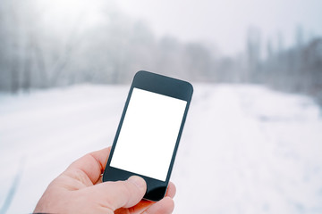 hand with mockup smartphone in winter forest