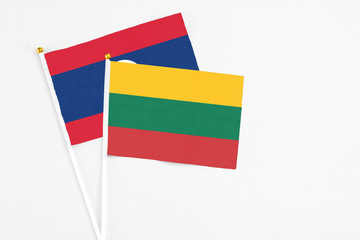 Lithuania and Laos stick flags on white background. High quality fabric, miniature national flag. Peaceful global concept.White floor for copy space.