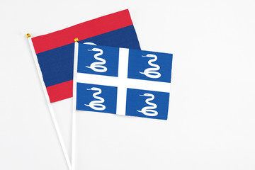 Martinique and Laos stick flags on white background. High quality fabric, miniature national flag. Peaceful global concept.White floor for copy space.
