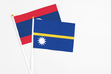 Nauru and Laos stick flags on white background. High quality fabric, miniature national flag. Peaceful global concept.White floor for copy space.