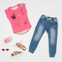 Fashion clothes - jean set and short sleeve blouse for girls; photo in neutral background.
