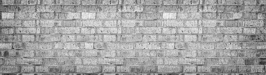 Wide gray brick wall texture. Rough light grey brickwork. Old cracked blocks panorama. Retro grunge widescreen background
