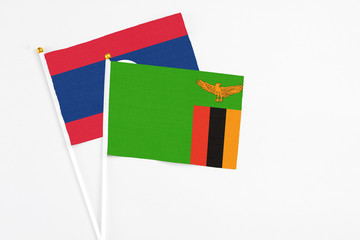 Zambia and Laos stick flags on white background. High quality fabric, miniature national flag. Peaceful global concept.White floor for copy space.