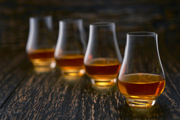 glasses of single malt whiskey on rustic wooden table selective focus.