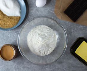 Ingredients for baking - flour, sugar, butter, plum, chocolade. stone or slate background.Top view.
