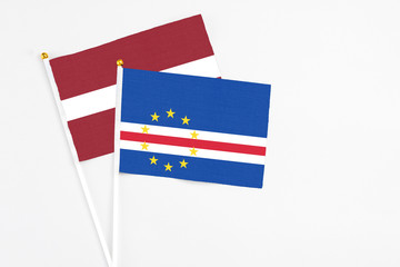 Cape Verde and Latvia stick flags on white background. High quality fabric, miniature national flag. Peaceful global concept.White floor for copy space.