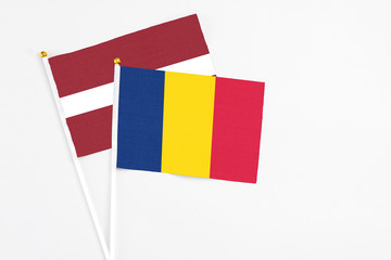 Chad and Latvia stick flags on white background. High quality fabric, miniature national flag. Peaceful global concept.White floor for copy space.