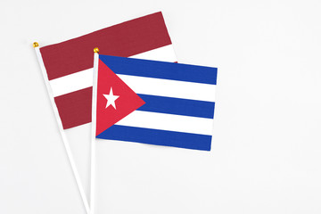 Cuba and Latvia stick flags on white background. High quality fabric, miniature national flag. Peaceful global concept.White floor for copy space.