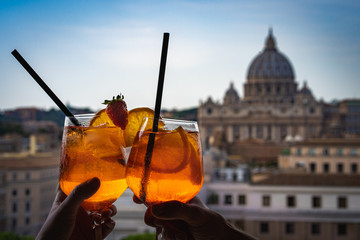 A couple is holding glasses of Aperol in the bar inside the Castle Sant'Angelo. Glasses of Aperol...