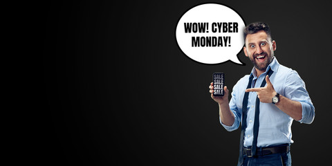 Portrait of man with speech bubble on black studio background. Copyspace for your advertising. Black friday, cyber monday, sales, money and cash, online purchases and payments. Shows phone screen.
