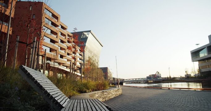 4K low angle wide shot with forward slide motion of Lambda, the new Edvard Munch museum, with famous paintings like The Anxiety, in a late autumn sunset in the Bj&oslash;rvika quarter in Oslo, Norway.