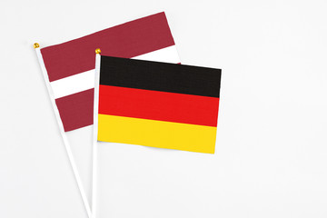 Germany and Latvia stick flags on white background. High quality fabric, miniature national flag. Peaceful global concept.White floor for copy space.