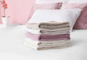 Fototapeta na wymiar Stack of soft clean towels on bed