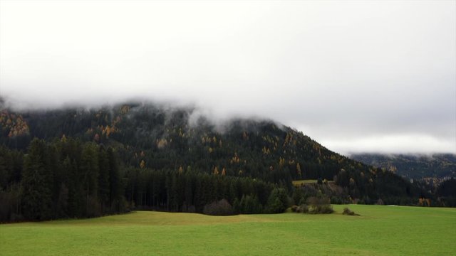 Time lapse video of alpine forest in Italian Alps during autumn with fog.
