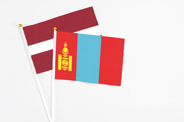 Mongolia and Latvia stick flags on white background. High quality fabric, miniature national flag. Peaceful global concept.White floor for copy space.