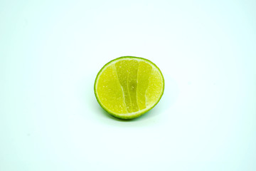 One piece of half sliced fresh green  lime  isolated on white background