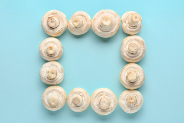 Frame made of fresh mushrooms on color background