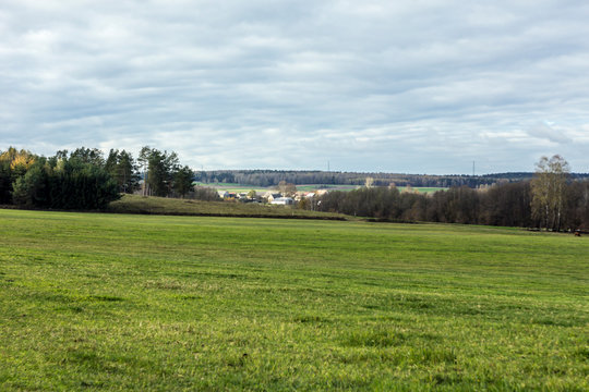 A little village among fields and pastures. Green meadow in the foreground. Autumn in Podlasie, Poland.