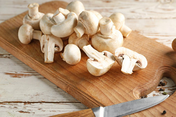Cutting board with fresh mushrooms on table