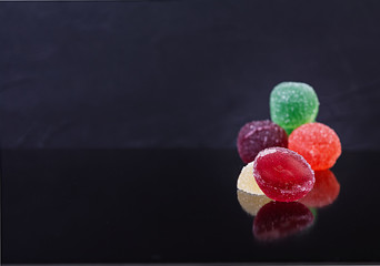 Colorful marmalade isolated on dark background. Delicious jujube balls.