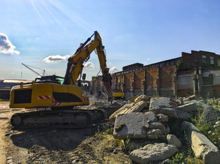 Demolition house using excavator in city. Rebuilding process. Remove equipment.