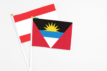 Antigua and Barbuda and Lebanon stick flags on white background. High quality fabric, miniature national flag. Peaceful global concept.White floor for copy space.