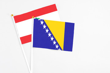 Bosnia Herzegovina and Lebanon stick flags on white background. High quality fabric, miniature national flag. Peaceful global concept.White floor for copy space.