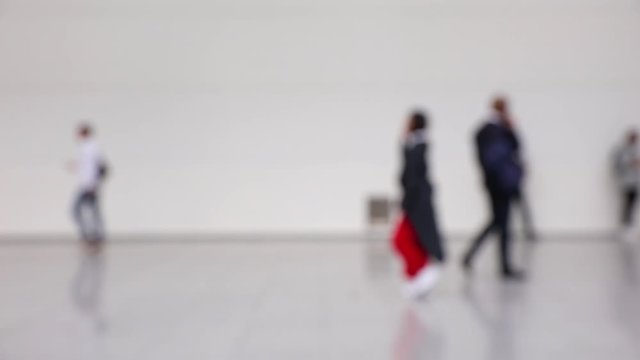 Blurred crowd of people walking by in a hallway