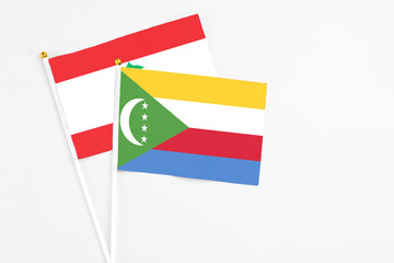 Comoros and Lebanon stick flags on white background. High quality fabric, miniature national flag. Peaceful global concept.White floor for copy space.