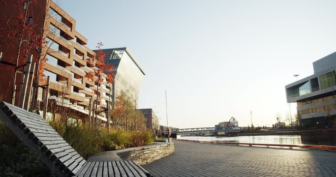 4K low angle wide shot with forward slide motion of Lambda, the new Edvard Munch museum, with famous paintings like The Dance of Life, in a late autumn sunset in the Bj&oslash;rvika quarter in Oslo, Norway.