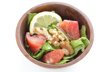 Tomato and walnut salad on white background with copy space