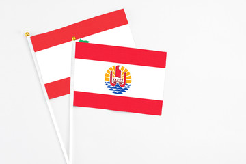 French Polynesia and Lebanon stick flags on white background. High quality fabric, miniature national flag. Peaceful global concept.White floor for copy space.