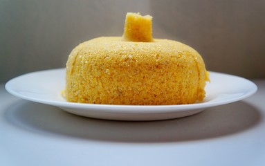 Brazilian couscous on white plate. Traditional Brazilian food prepared from corn flour.