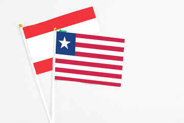 Fototapeta premium Liberia and Lebanon stick flags on white background. High quality fabric, miniature national flag. Peaceful global concept.White floor for copy space.