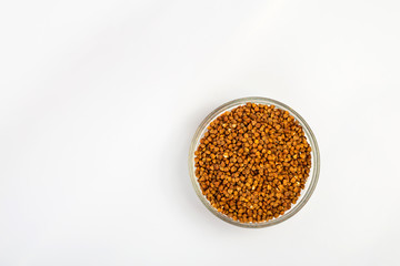 Buckwheat groats in a plate on a white background. Buckwheat porridge in a small plate. Diet breakfast. Healthy food.