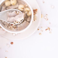 Tasty Four Tonics Herb Flavor Soup, Taiwanese traditional food with herbs, pork intestines on white wooden table, close up, flat lay, top view.